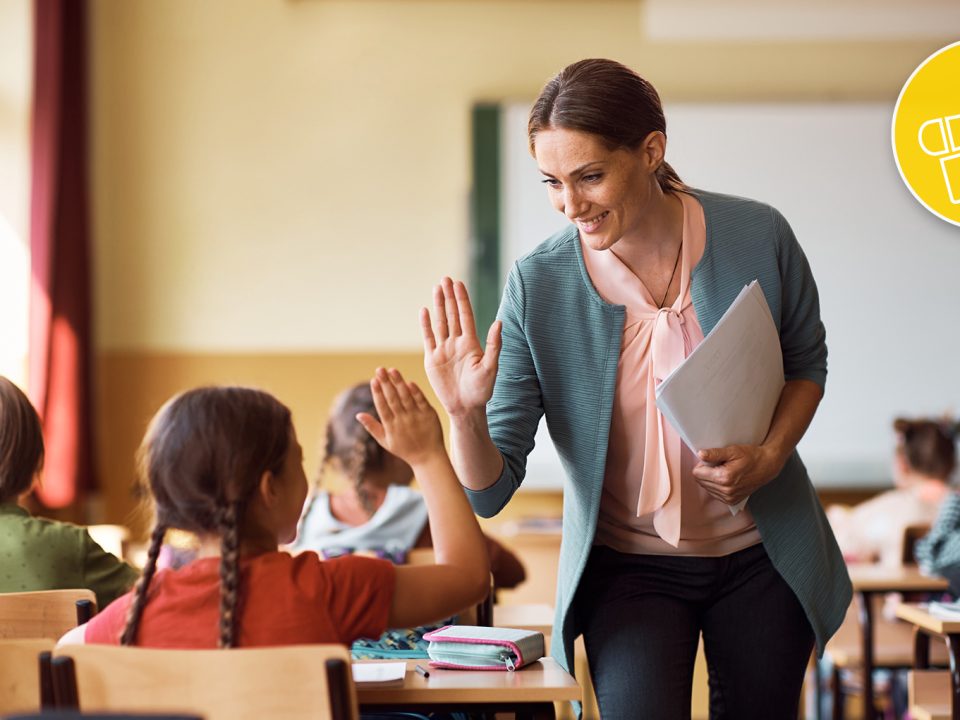 Lehrerin klatscht mit ihren Schülern nach bestandener ÖSD KID Deutschprüfung ein.